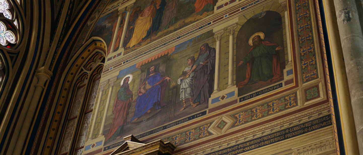 Detailed religious mural painted inside a historic cathedral archway.