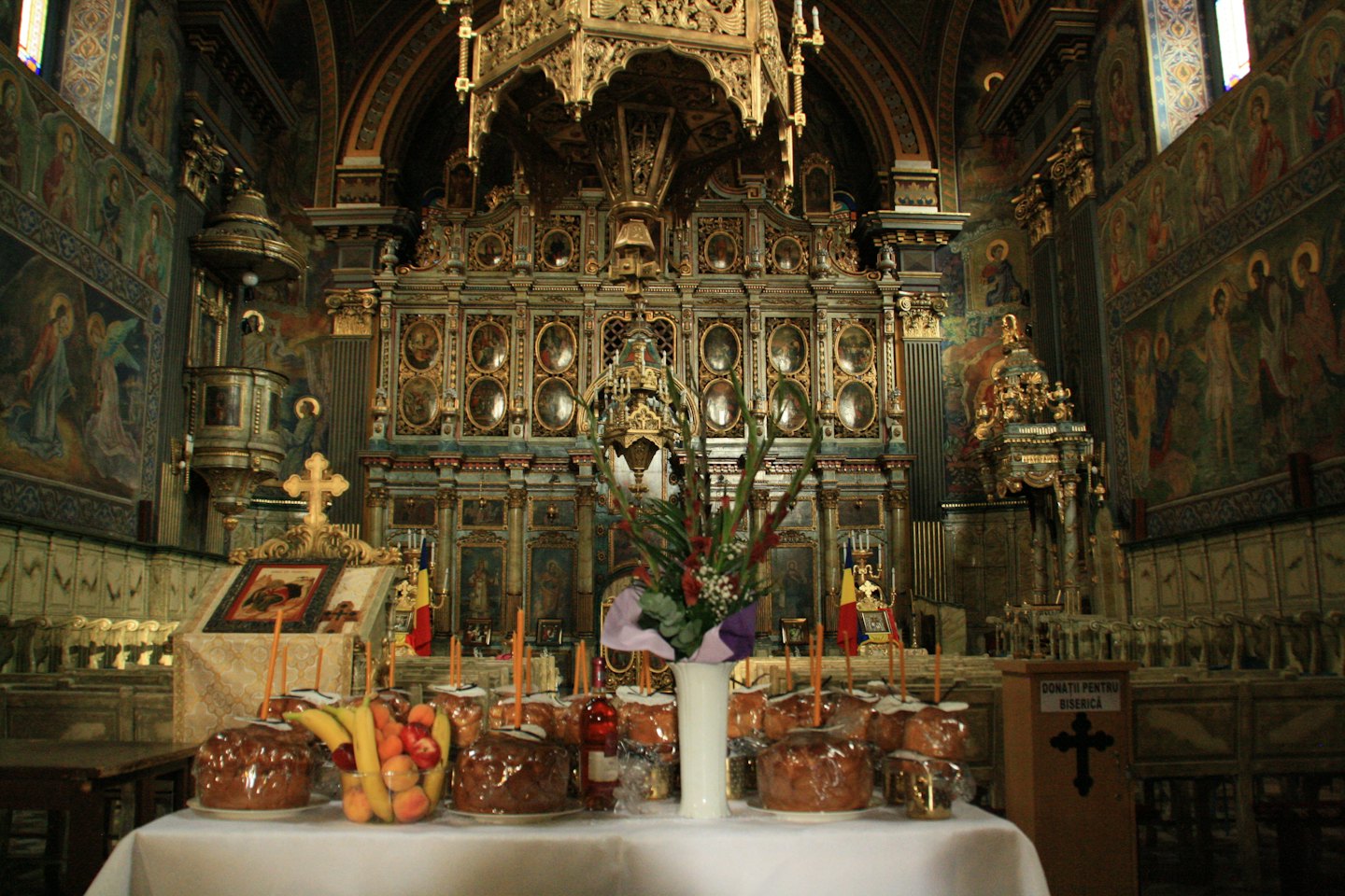 Candles and offerings placed on a table in an Orthodox church.