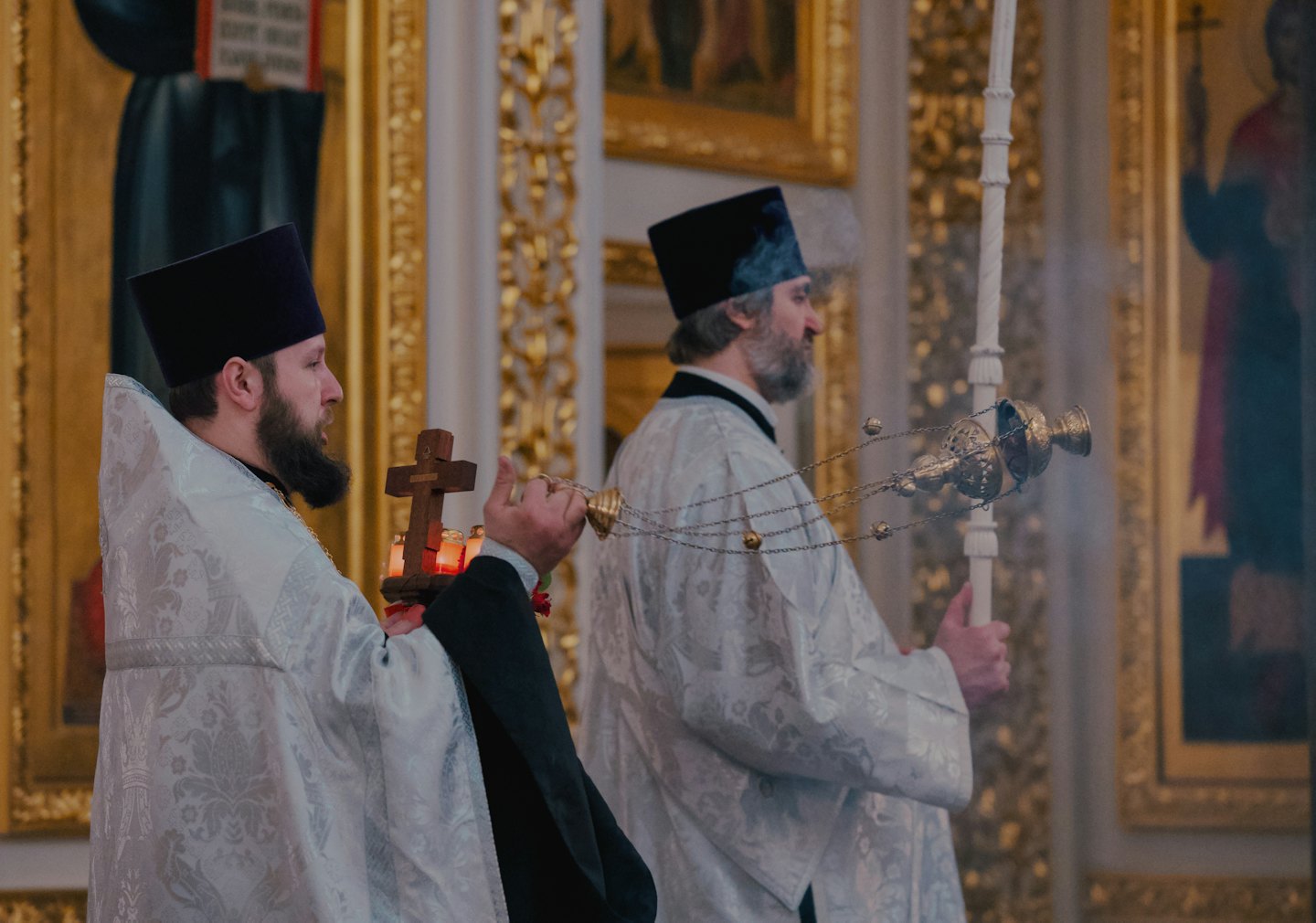 Two Orthodox priests perform a religious ceremony in a church.
